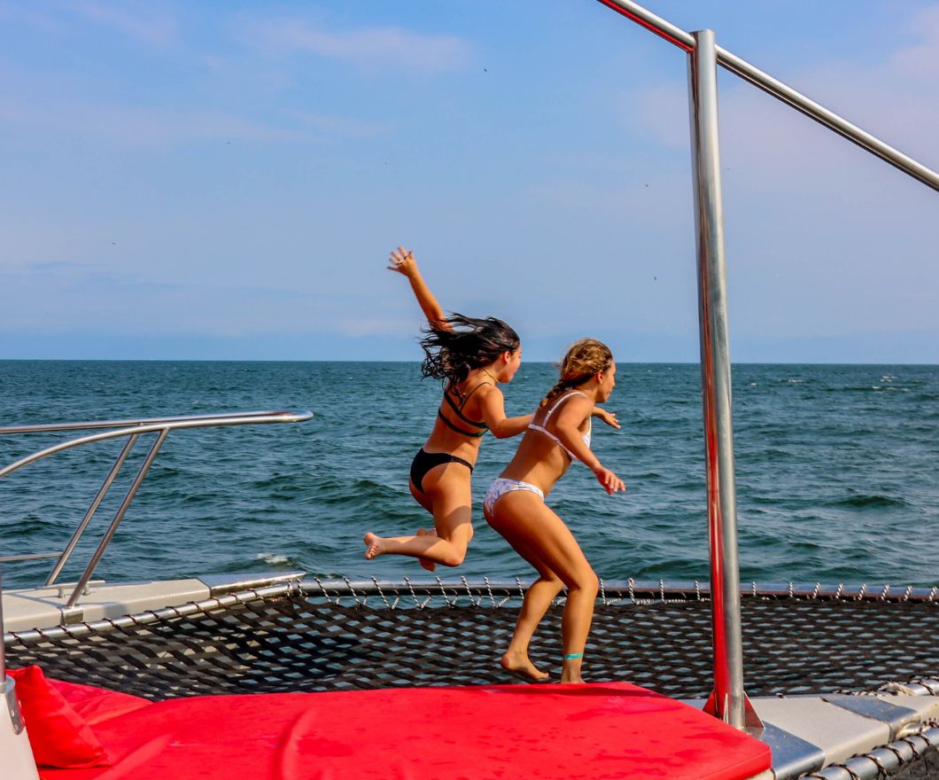 girls jumping on boat cruise
